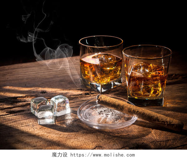 木制桌子上的小杯威士忌和雪茄